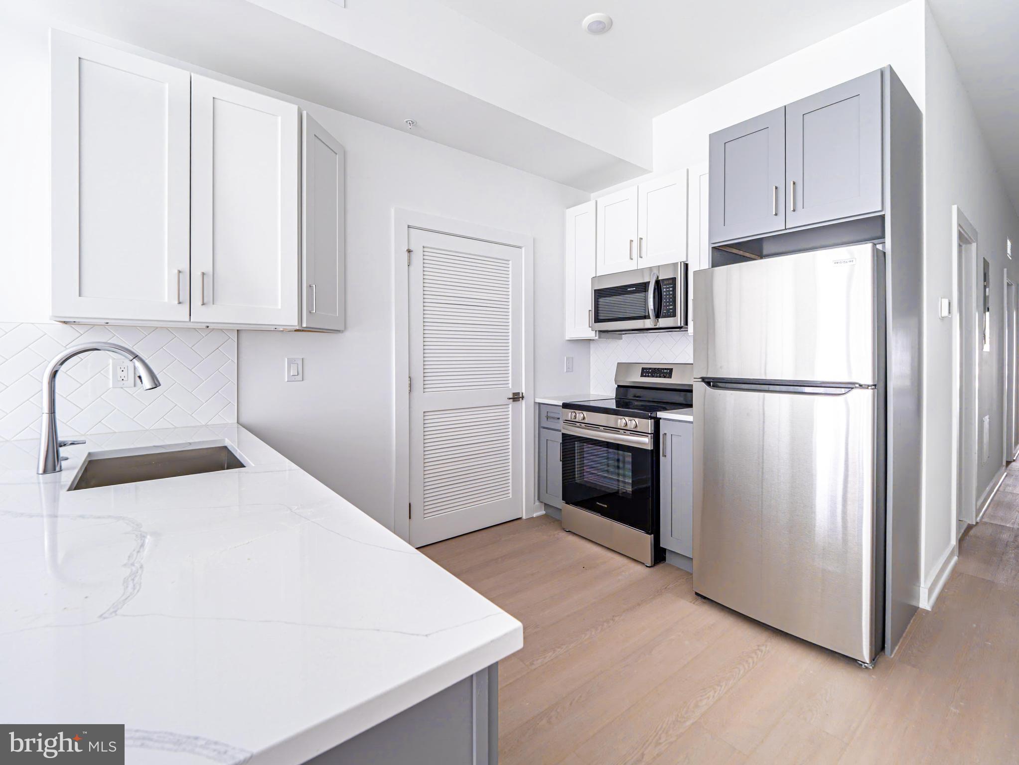 2403-2407 West Thompson Street, Unit 4 Philadelphia, PA 19121 - Photo 5 of 13 a kitchen with a refrigerator sink and cabinets