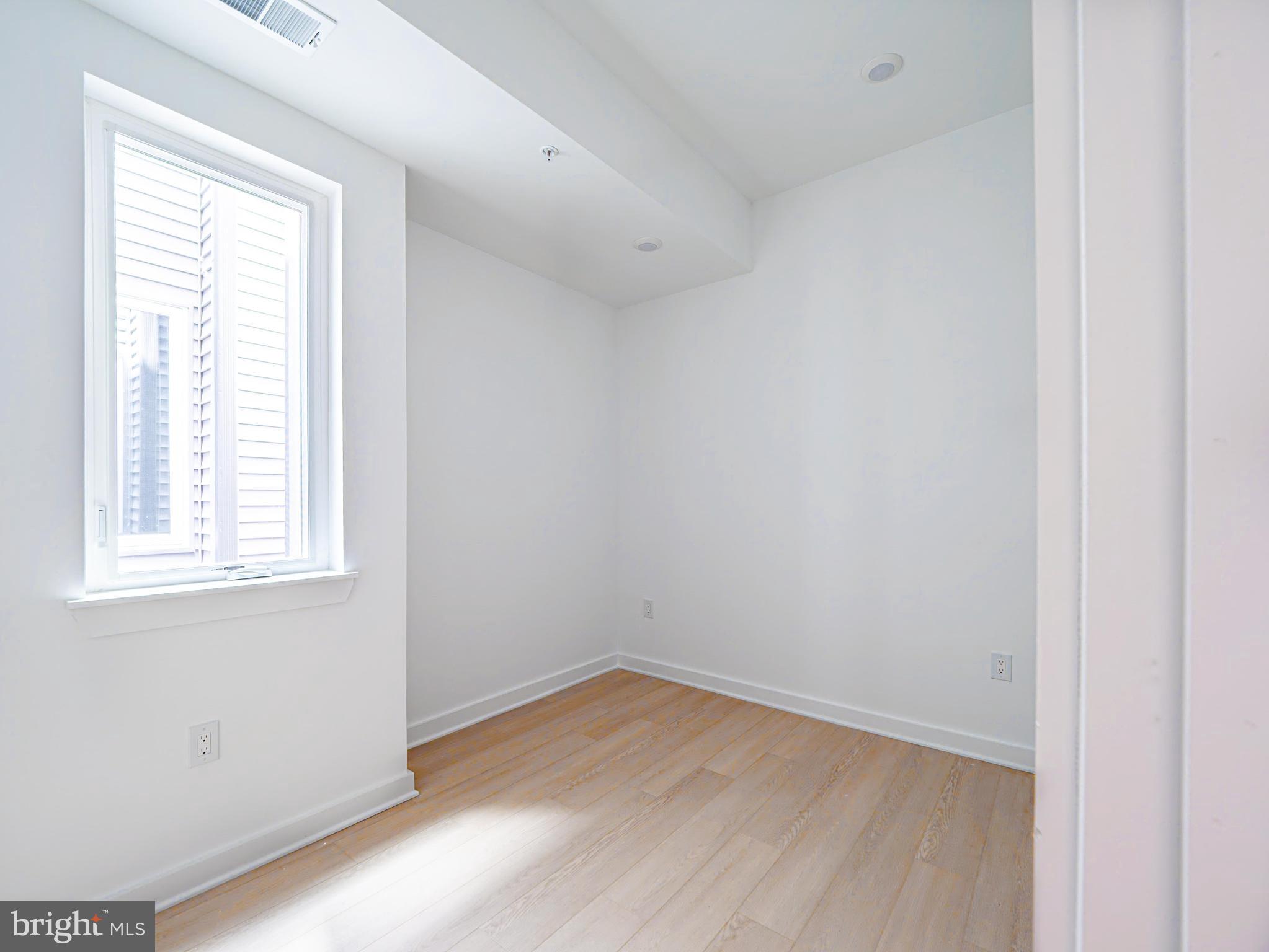 2403-2407 West Thompson Street, Unit 4 Philadelphia, PA 19121 - Photo 8 of 13 an empty room with wooden floor and windows