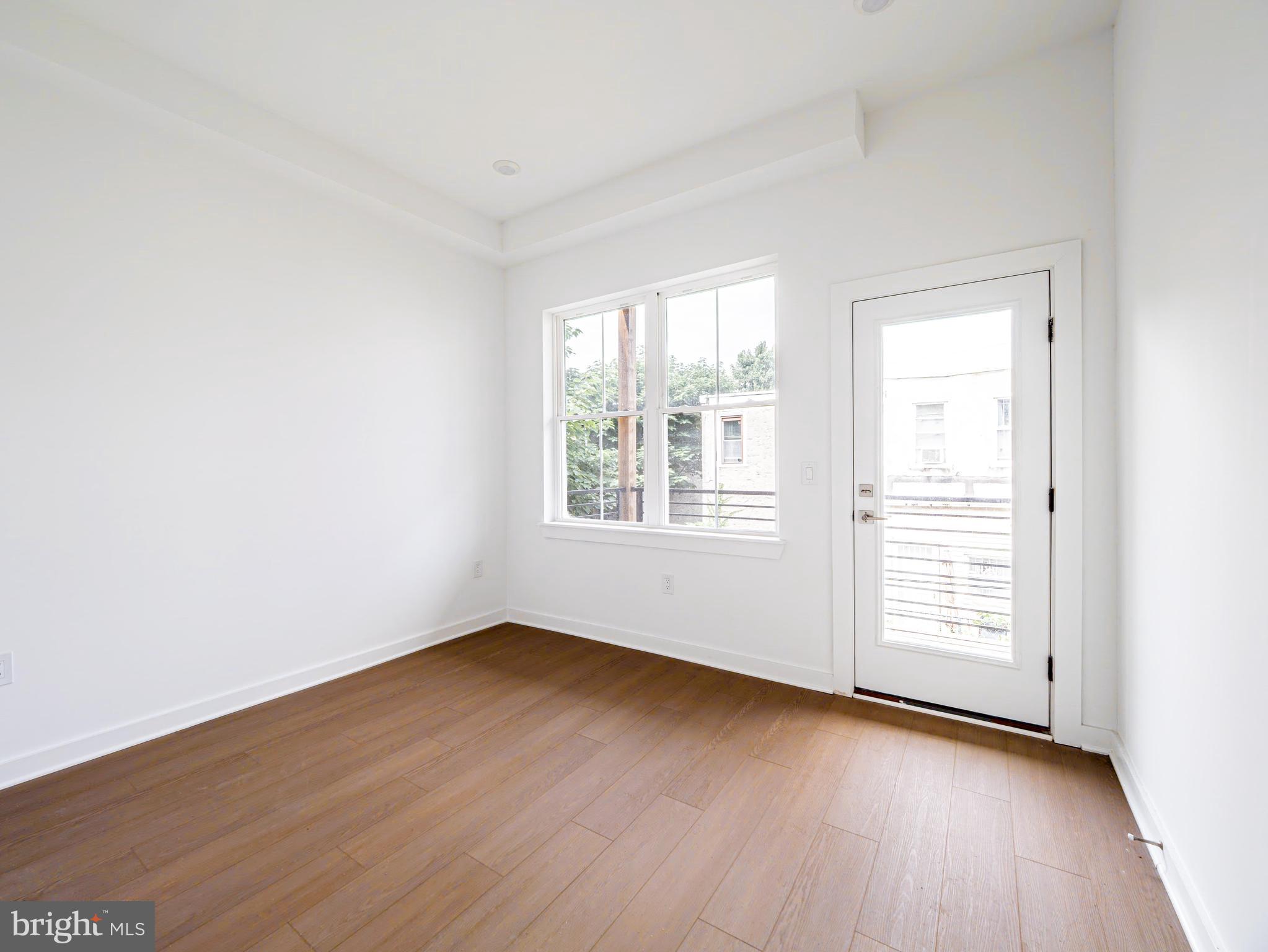 2403-2407 West Thompson Street, Unit 4 Philadelphia, PA 19121 - Photo 10 of 13 an empty room with wooden floor and windows