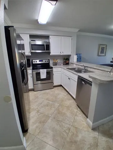 a kitchen with stainless steel appliances granite countertop a sink stove microwave and refrigerator