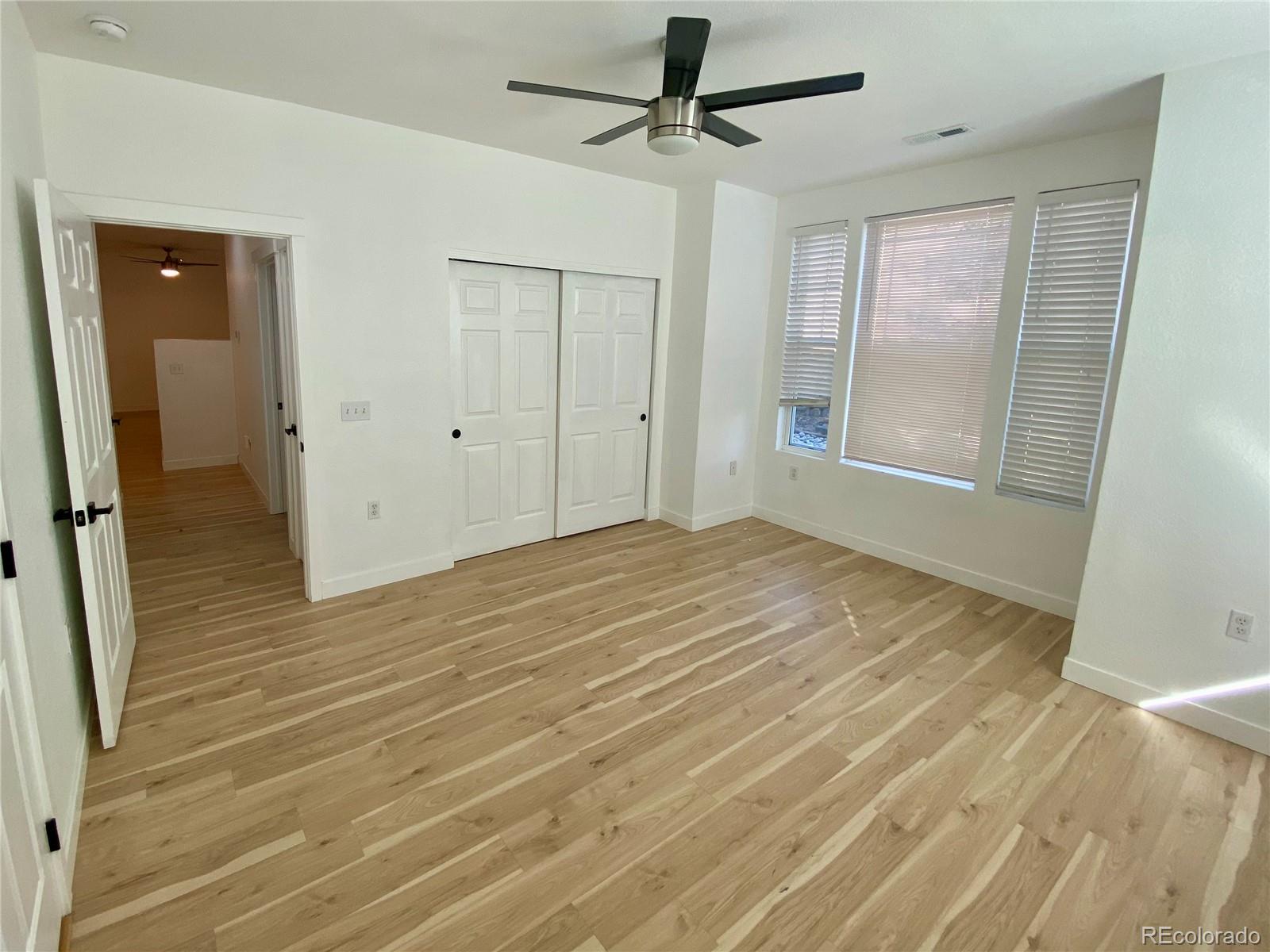 6722 South Winnipeg Circle, Unit 103 Aurora, CO 80016 - Photo 11 of 19 a view of a livingroom with wooden floor and a ceiling fan
