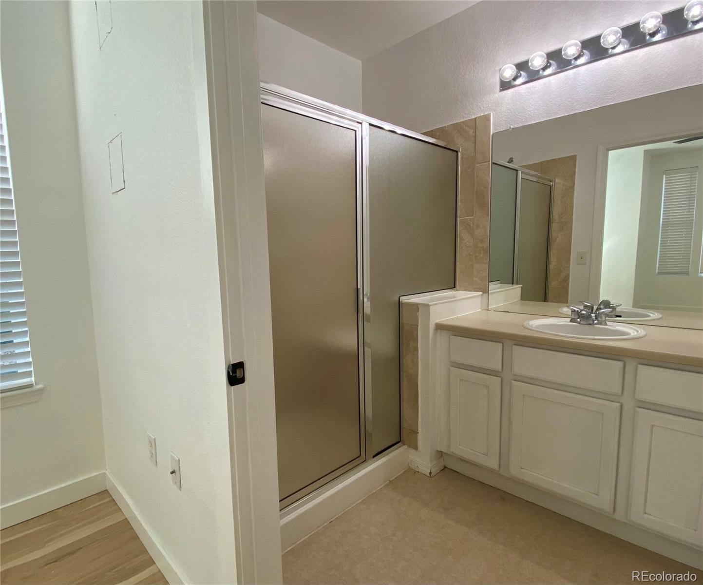 6722 South Winnipeg Circle, Unit 103 Aurora, CO 80016 - Photo 12 of 19 a bathroom with a double vanity sink mirror and shower
