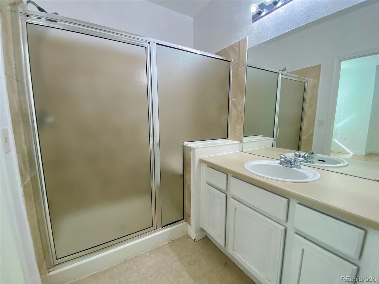 6722 South Winnipeg Circle, Unit 103 Aurora, CO 80016 - Photo 13 of 19 a bathroom with a shower sink and mirror