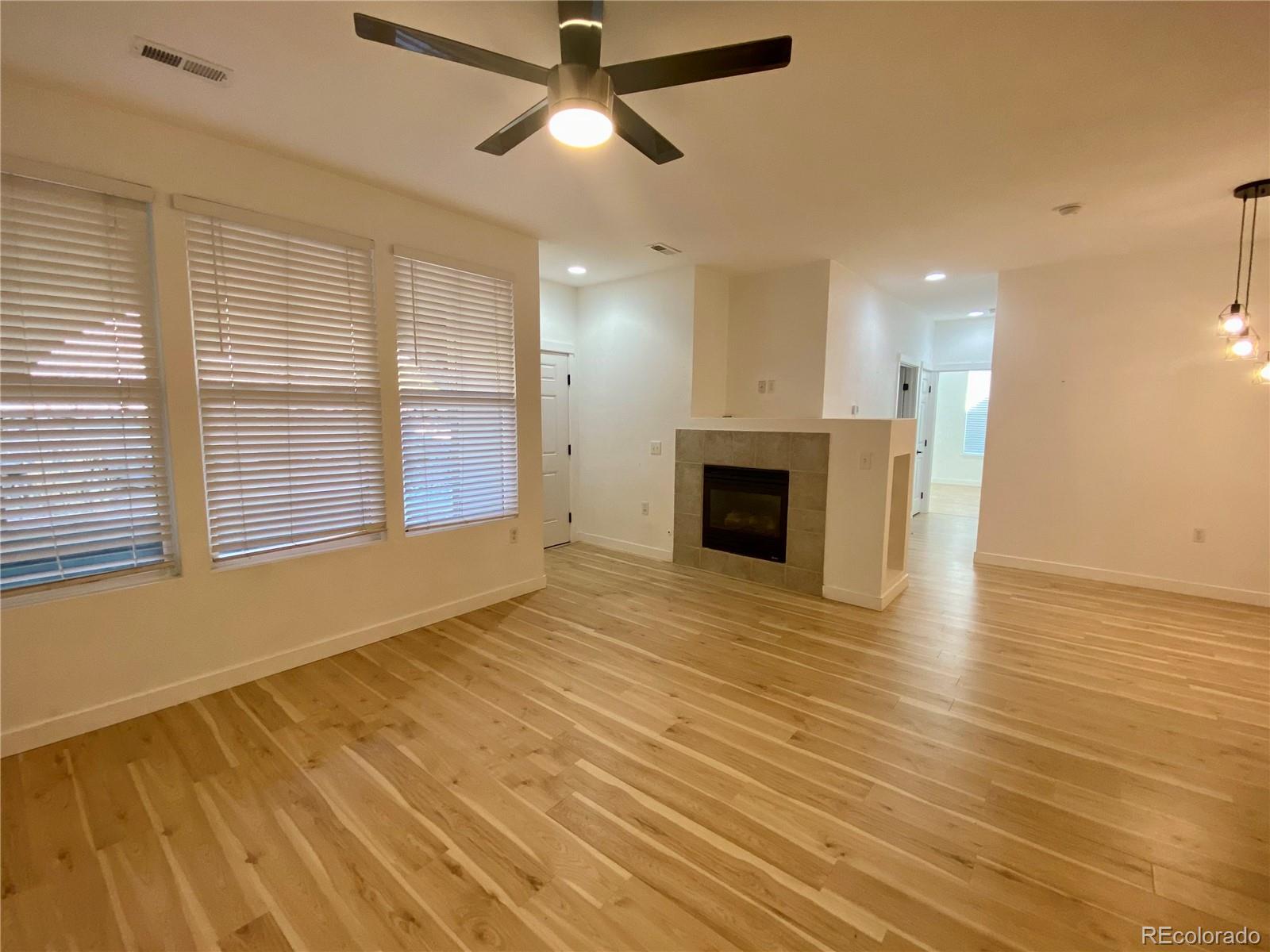 6722 South Winnipeg Circle, Unit 103 Aurora, CO 80016 - Photo 4 of 19 a view of empty room with wooden floor and fireplace