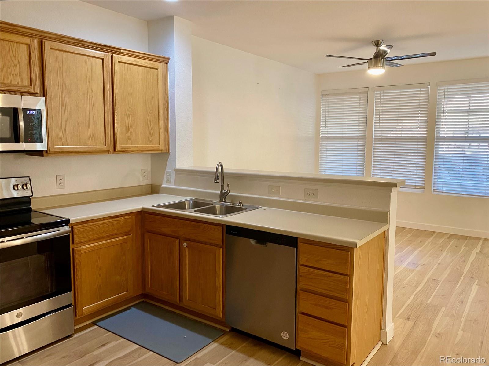 6722 South Winnipeg Circle, Unit 103 Aurora, CO 80016 - Photo 8 of 19 a kitchen with a sink cabinets and window