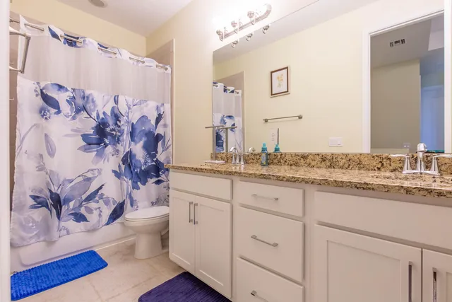 a spacious bathroom with double vanity and a mirror