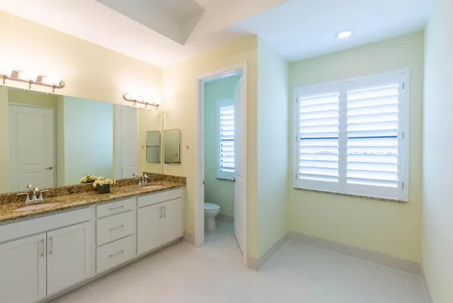 a bathroom with a granite countertop shower sink and mirror