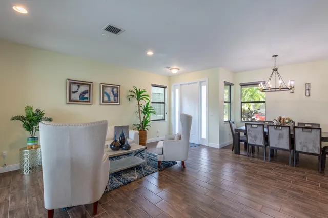 a living room with furniture dining table a window and a potted plant