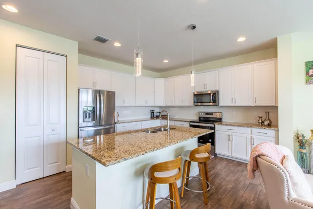 a kitchen with a refrigerator a stove top oven a sink and cabinets