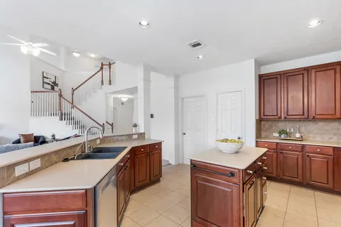 a kitchen with a sink a stove cabinets and wooden floor