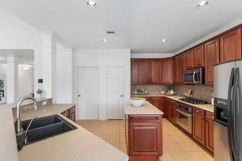 a kitchen with stainless steel appliances granite countertop a sink stove and refrigerator