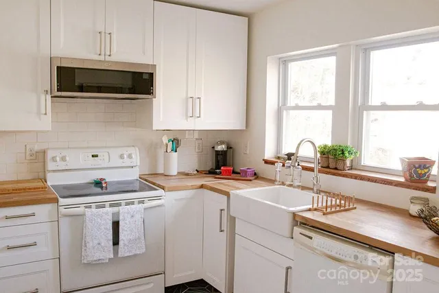 a kitchen with stainless steel appliances white cabinets and a stove top oven