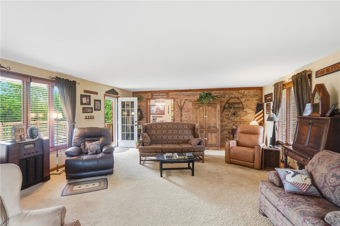 4170 Johnson Road Springfield, OH 45502 - Photo 18 of 54 A comfortable living space featuring soft carpeting and a brick accent wall with classic furnishings.