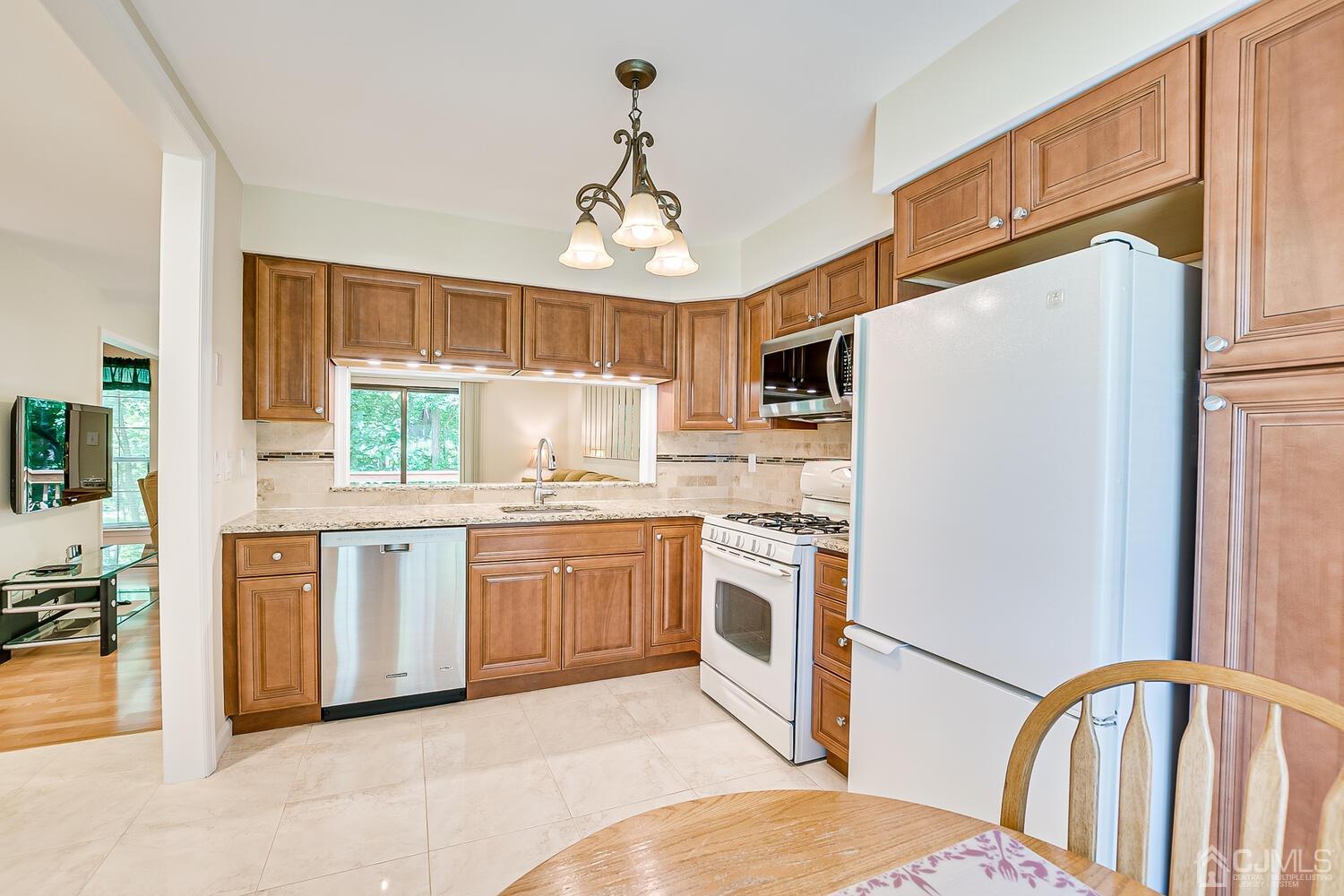 1606 Timber Oaks Road Edison, NJ 08820 - Photo 11 of 33 a kitchen with stainless steel appliances granite countertop a refrigerator a stove a sink dishwasher and white cabinets with wooden floor
