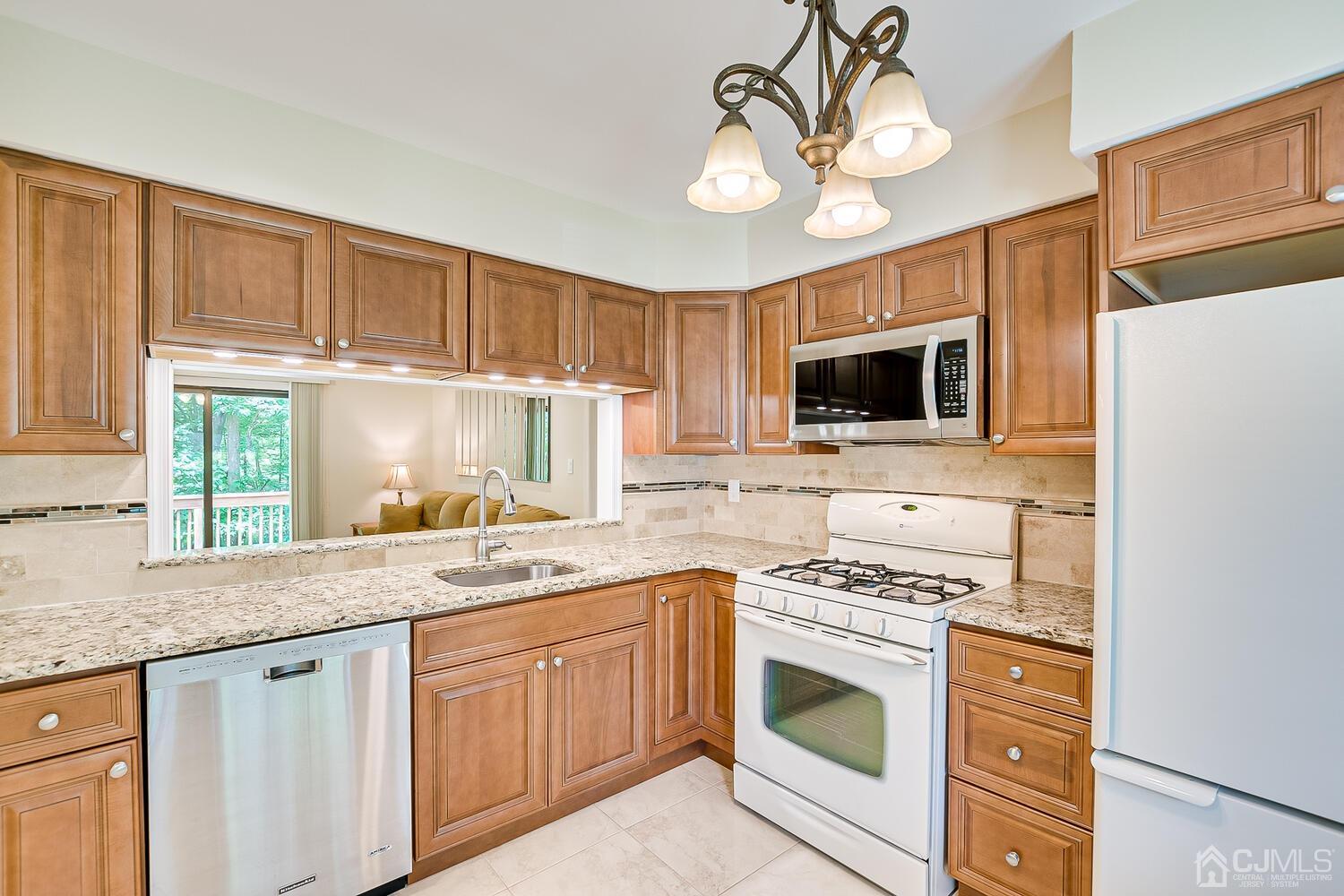 1606 Timber Oaks Road Edison, NJ 08820 - Photo 12 of 33 a kitchen with stainless steel appliances granite countertop a stove a sink and a microwave