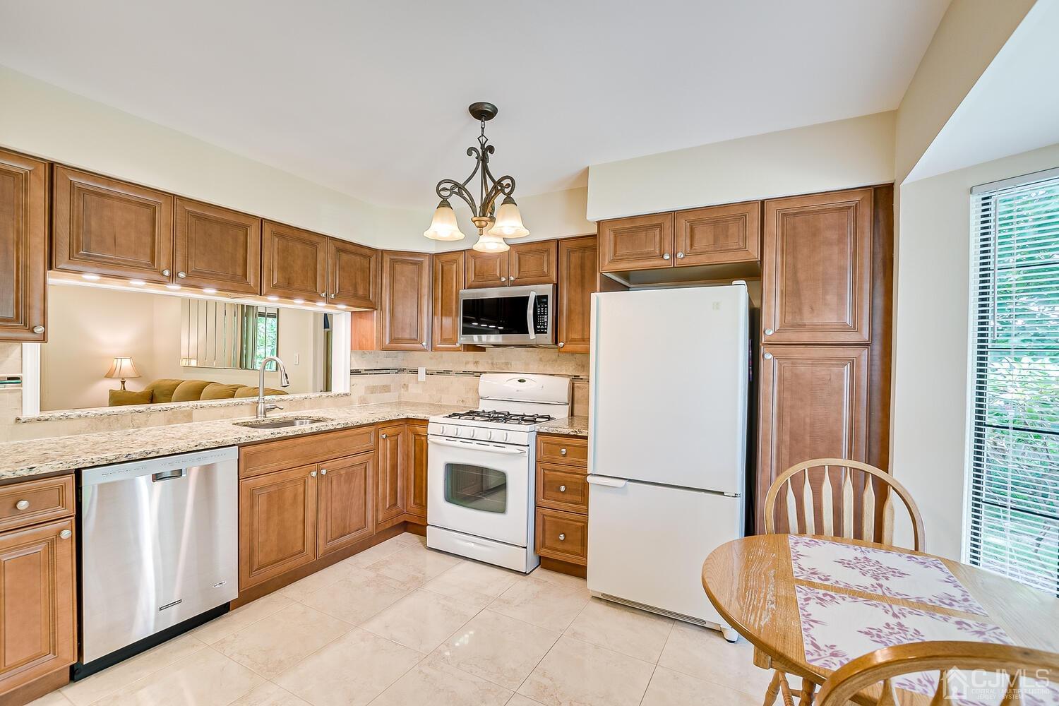 1606 Timber Oaks Road Edison, NJ 08820 - Photo 9 of 33 a kitchen with stainless steel appliances granite countertop a stove a sink dishwasher a refrigerator with a dining table and chairs