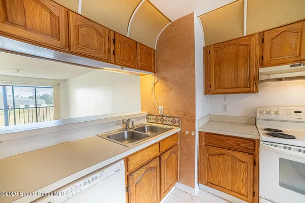 a kitchen with stainless steel appliances granite countertop a sink and cabinets with wooden floor