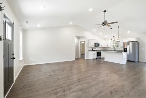 a view of kitchen with refrigerator stove and wooden floor
