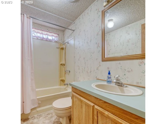 1199 North Terry Street Eugene, OR 97402 - Photo 16 of 32 a bathroom with a sink a toilet and a large mirror
