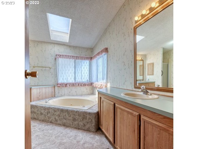 1199 North Terry Street Eugene, OR 97402 - Photo 20 of 32 a bathroom with a granite countertop tub sink and mirror