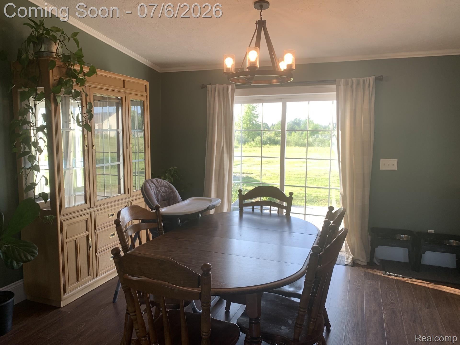4168 Harris Road Fort Gratiot, MI 48059 - Photo 20 of 30 Dining area featuring wood-finish flooring, a contemporary chandelier, and a sliding glass door providing abundant natural light