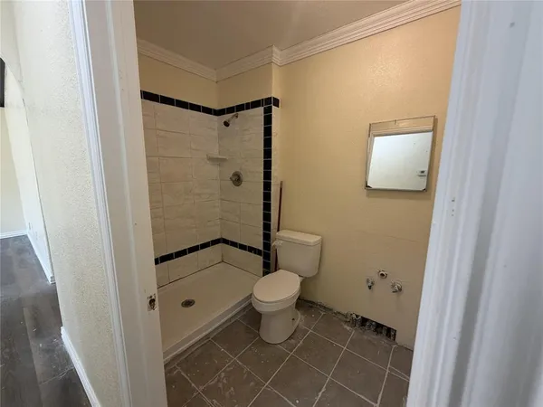a bathroom with a toilet and a shower