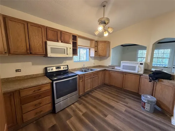 a kitchen with stainless steel appliances granite countertop a sink cabinets and wooden floor