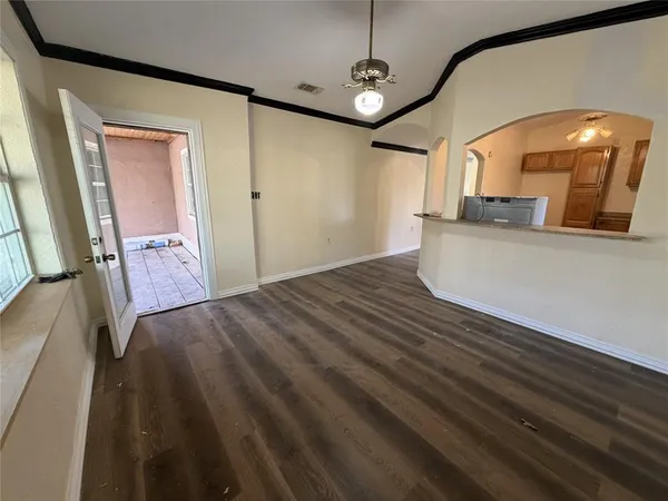 a view of a hallway to a bedroom with wooden floor and windows