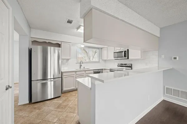 a kitchen with stainless steel appliances a refrigerator sink and cabinets
