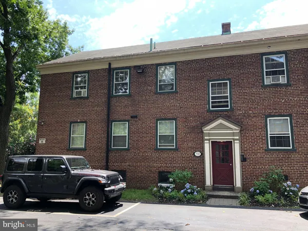 a couple of cars parked in front of a brick building