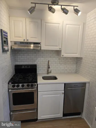 a kitchen with granite countertop white cabinets and appliances