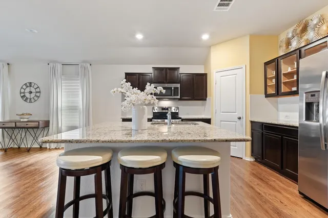 a kitchen with stainless steel appliances granite countertop a stove top oven a sink a counter top space and cabinets