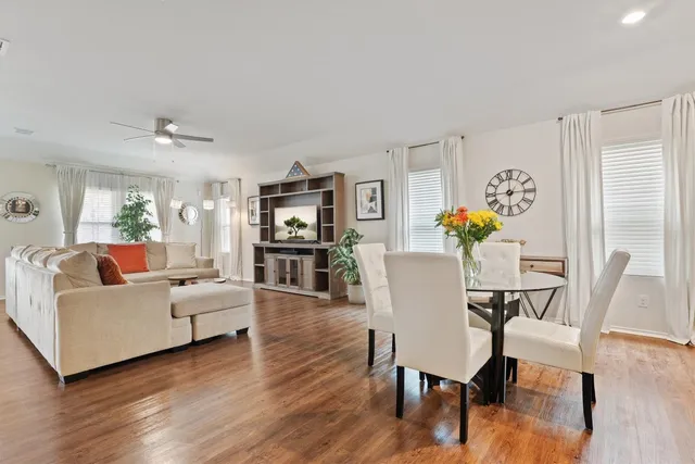 a kitchen with stainless steel appliances kitchen island granite countertop a stove a refrigerator a sink a dining table and chairs