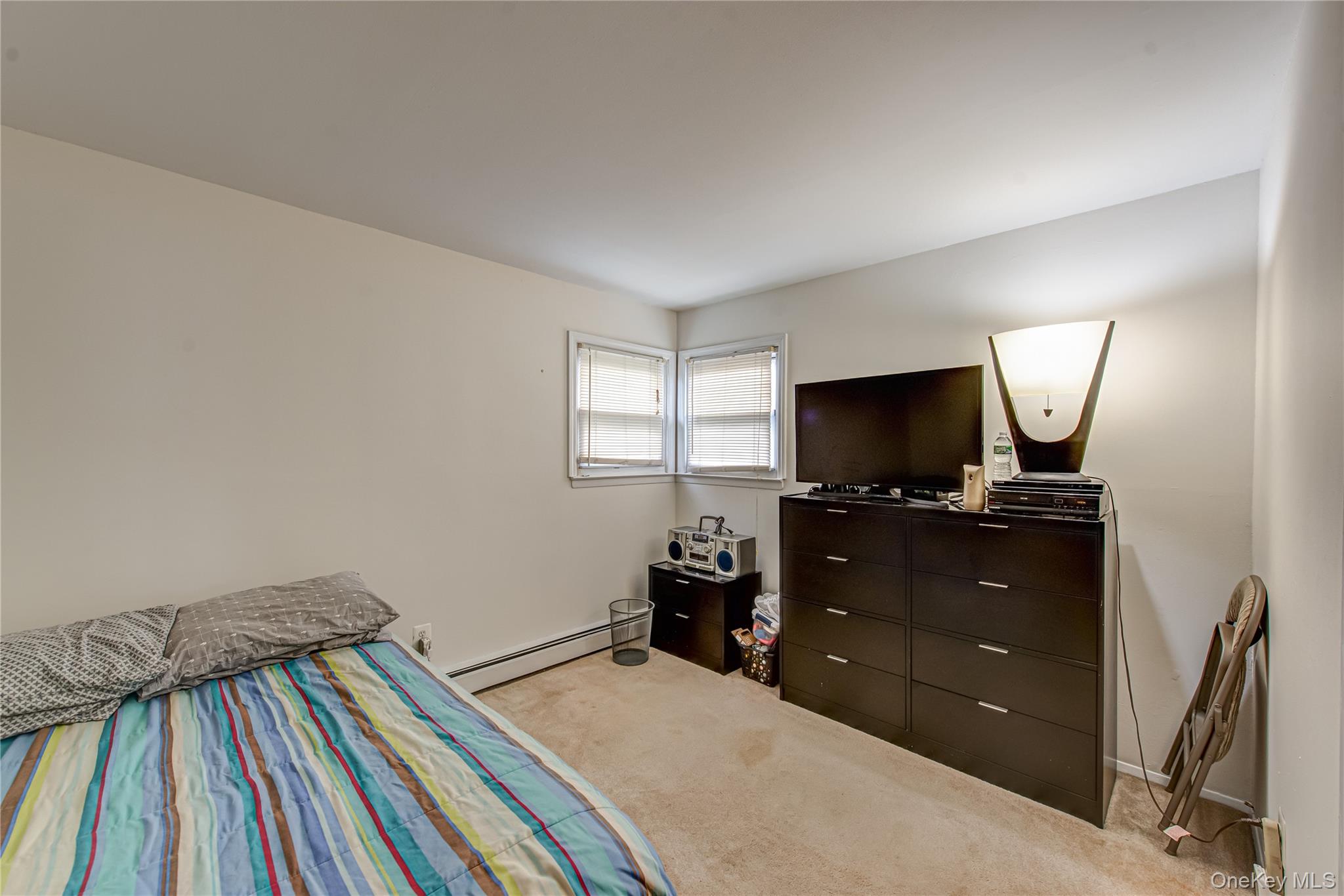 15 Major Road Massapequa, NY 11758 - Photo 13 of 25 a bedroom with a bed and a flat tv screen on dresser