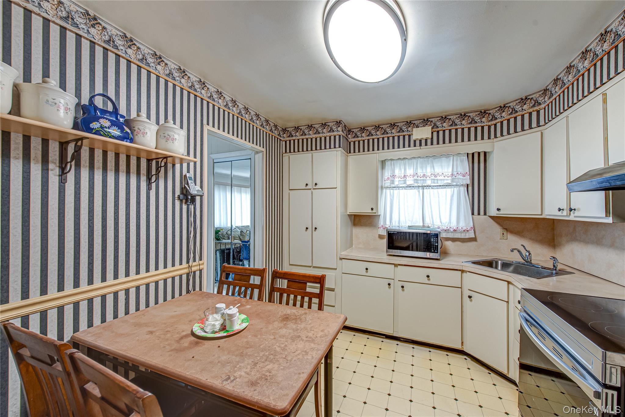 15 Major Road Massapequa, NY 11758 - Photo 10 of 25 a kitchen with granite countertop a sink a stove a dining table and chairs