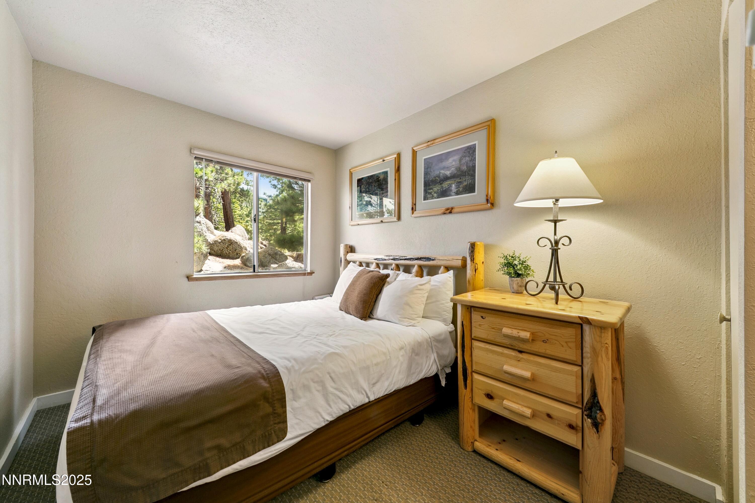 305 Galaxy Lane, Unit 7 Stateline, NV 89449 - Photo 23 of 61 a bedroom with a bed and a lamp on dresser