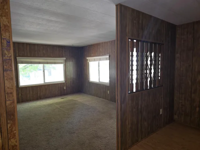 a view of an empty room with chandelier and window
