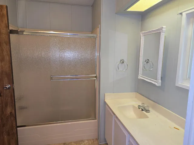 a bathroom with a tub a sink and mirror