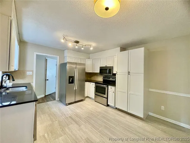 a kitchen with a refrigerator and a sink