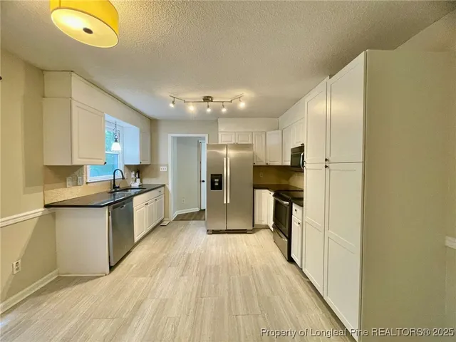 a large kitchen with cabinets and stainless steel appliances