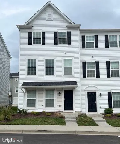 a front view of a house with yard and parking