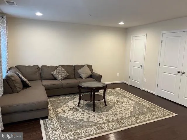 an empty room with wooden floor and window