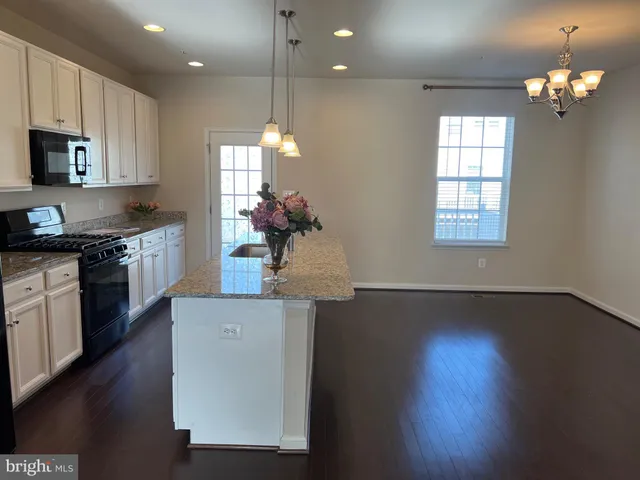 a kitchen with stainless steel appliances granite countertop a sink a microwave a refrigerator and a granite counter tops