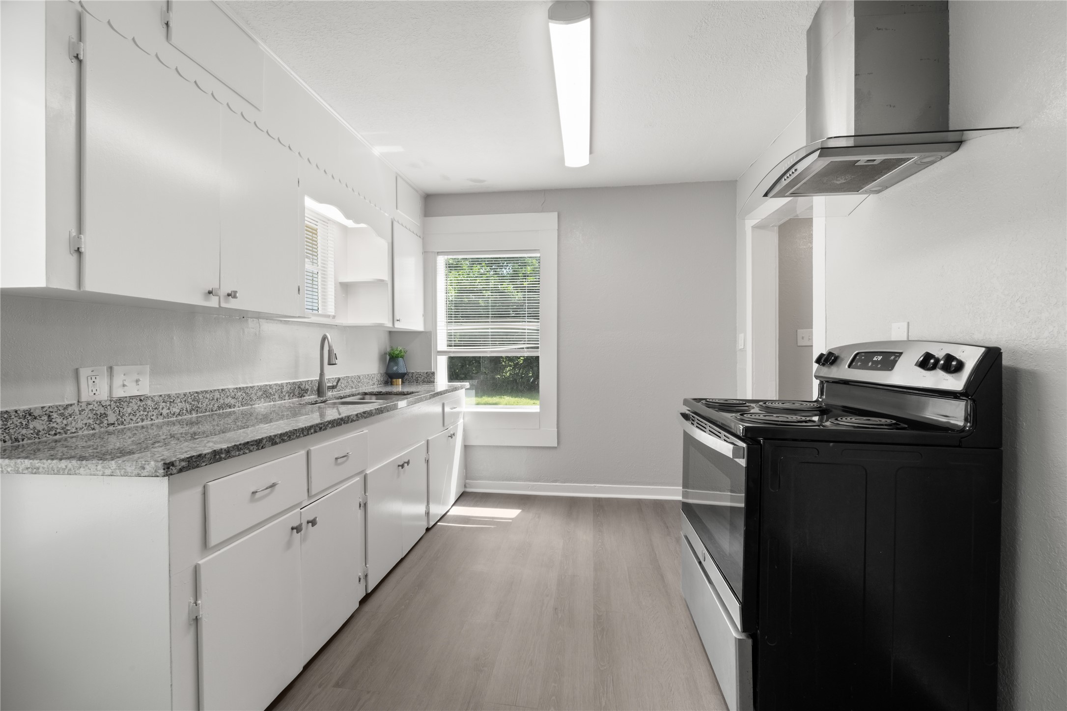 9210 Compton Street Houston, TX 77016 - Photo 3 of 50 Bright and modern kitchen featuring sleek granite countertops, ample cabinet space, and a contemporary stainless steel range.