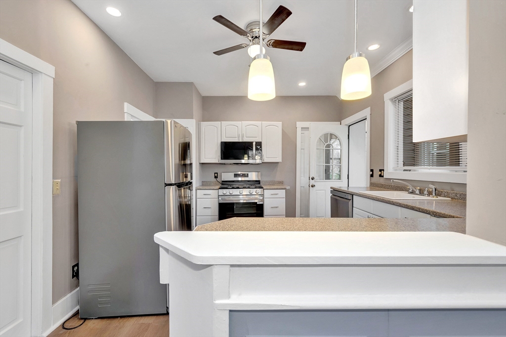 24 Taylor Street, Unit 1 Gloucester, MA 01930 - Photo 10 of 29 a kitchen with stainless steel appliances a refrigerator and a stove top oven
