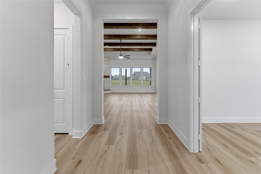 2208 Continent Court Krum, TX 76249 - Photo 5 of 26 Hallway with wood-finish flooring, white trim, and doors