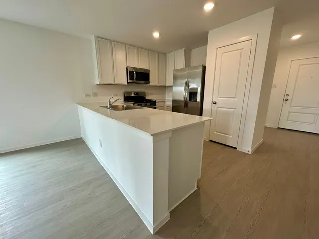 a kitchen with refrigerator cabinets and wooden floor
