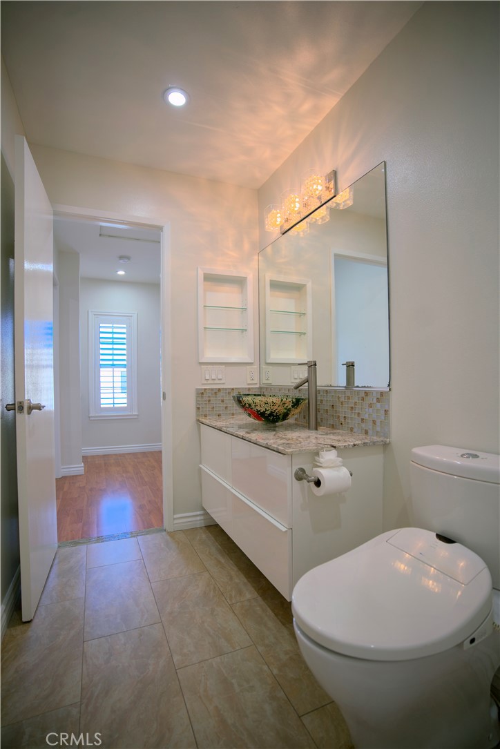 10 Raleigh Irvine, CA 92604 - Photo 9 of 28 a bathroom with a granite countertop toilet a sink and mirror