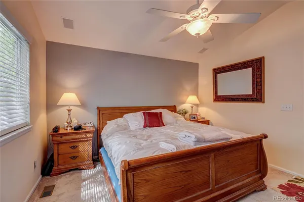 a bedroom with a bed and a lamp on dresser