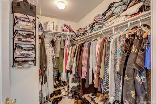 a view of walk in closet with clothes